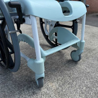 Etac Clean Self Propelled Shower Commode Chair in bathroom with man 