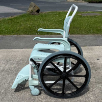 Etac Clean Self Propelled Shower Commode Chair in bathroom with lady in mirror