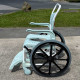 Etac Clean Self Propelled Shower Commode Chair in bathroom with lady in mirror