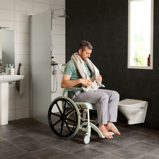 Etac Clean Self Propelled Shower Commode Chair in bathroom with man 