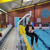 Oxford Dipper Pool hoist with Ranger Seat by pool with lady